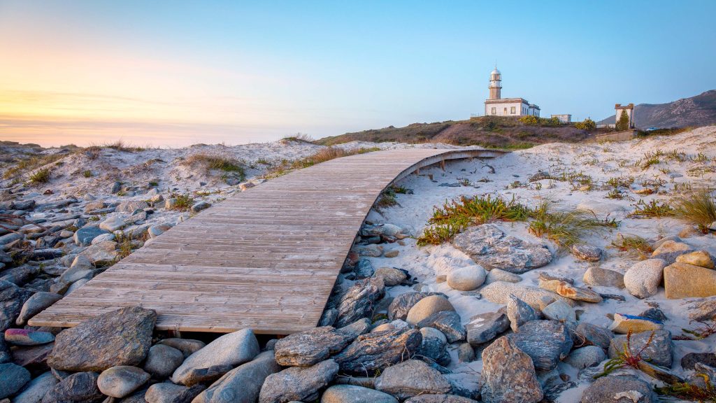 Lariño Lighthouse at Punta Ínsua rocky outcrop during sunset, Carnota, Galicia, Spain