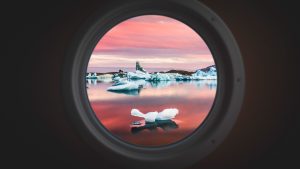 Read more about the article Floating icebergs seen through a ship’s porthole, Jökulsárlón, a glacial lagoon in Iceland