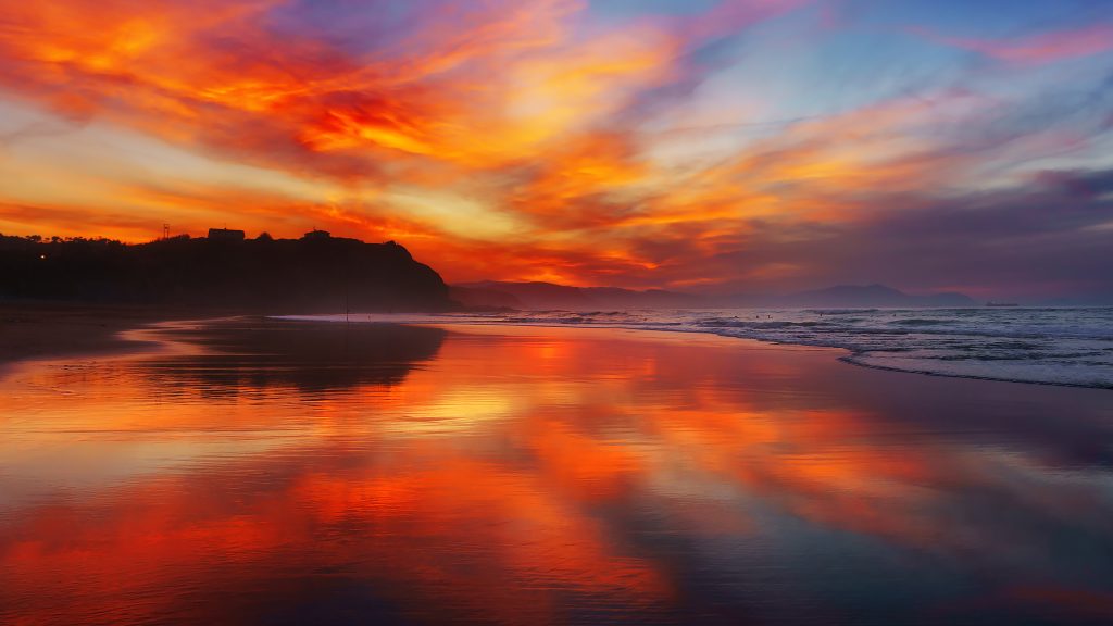 Red sunset over Sopelana (Sopela) beach with reflections, Biscay, Basque Country, Spain