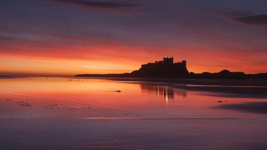 Colourful sunrise over Bamburgh Castle, Northumberland, England, UK