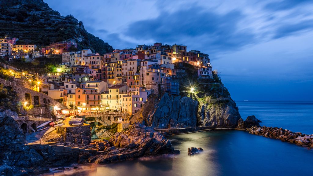 View of cityscape against cloudy sky, Manarola, Cinque Terre, Italy
