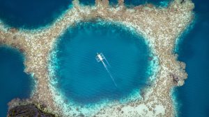 Read more about the article Aerial view of bangka boat sailing over coral reef, Twin Lagoon, Palawan, Philippines
