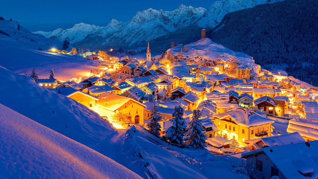 Snow covered Ardez village during winter dusk, Graubunden, Engadine, Switzerland