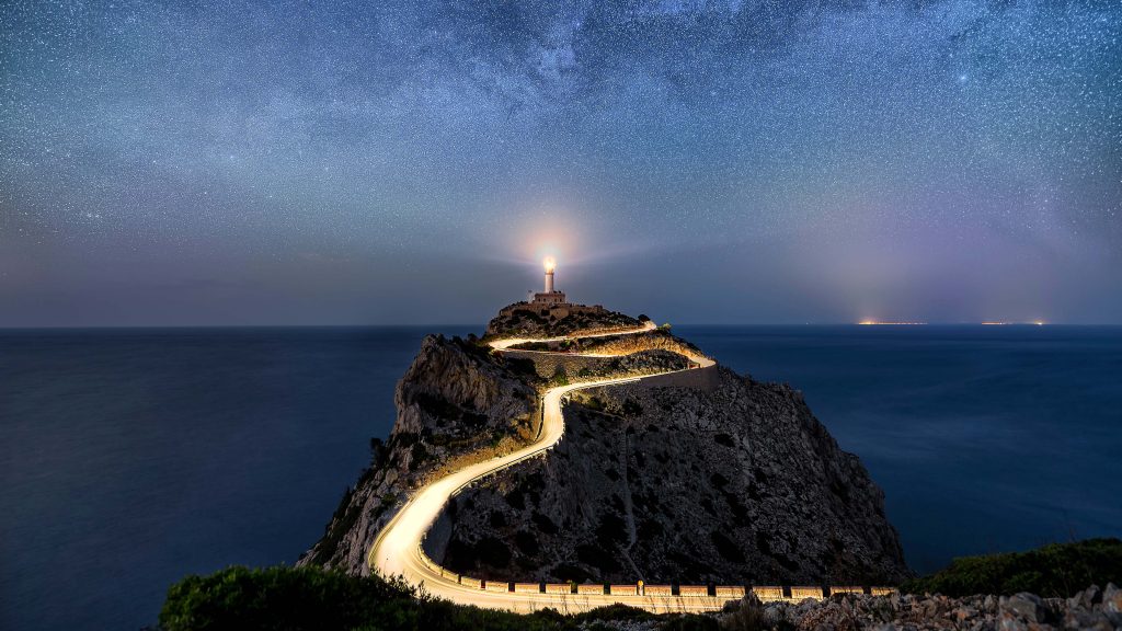 Milky Way stars and road at Far de Formentor lighthouse on Mallorca, Spain
