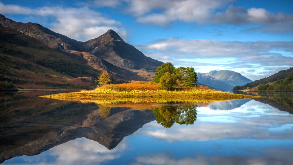 Still reflections of island and Pap of Glencoe in Loch Leven, Scotland, UK