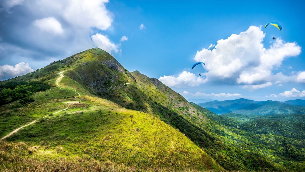 Hiking trail going up to the hilltop with paragliders flying in the sky, Hong Kong SAR
