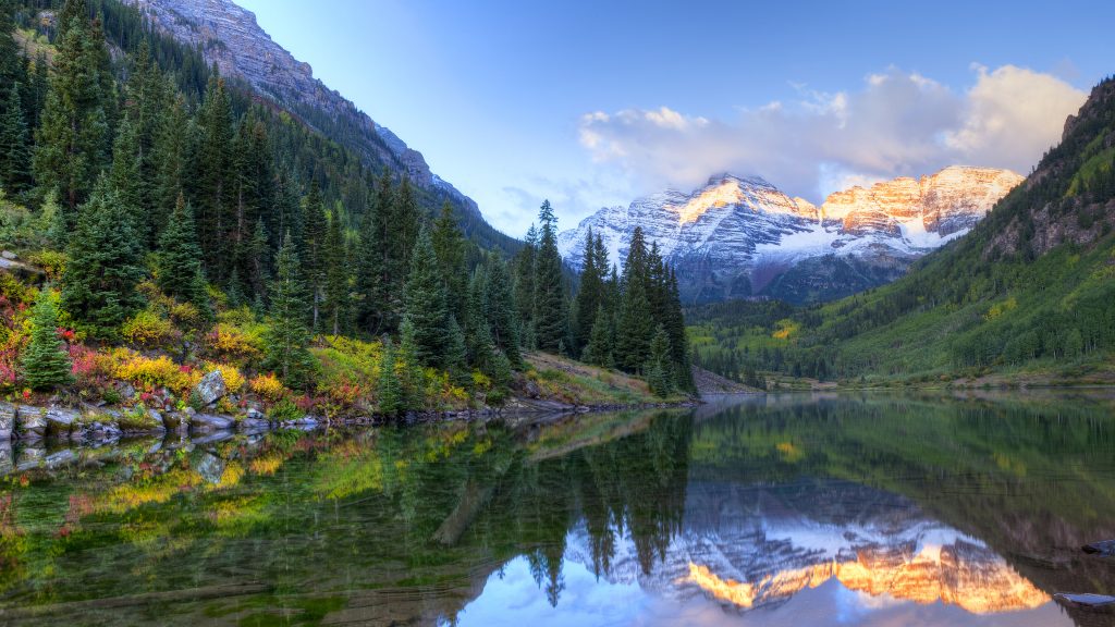 Reflection of snow capped Maroon Bells in Maroon Lake at fall sunrise, Colorado, USA