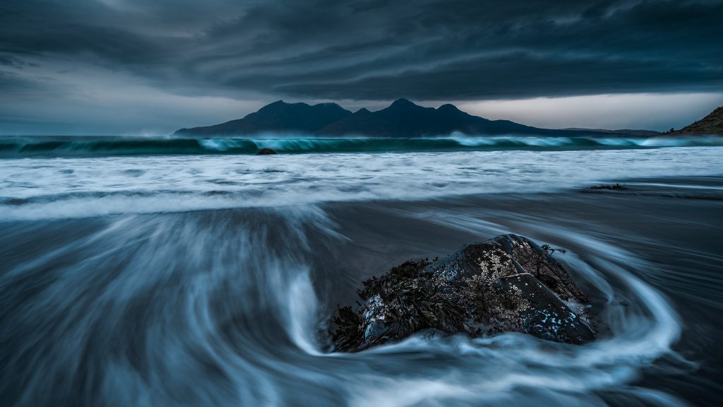 Lenticular clouds over Isle of Rùm seen from Eigg at dusk, Scotland, UK