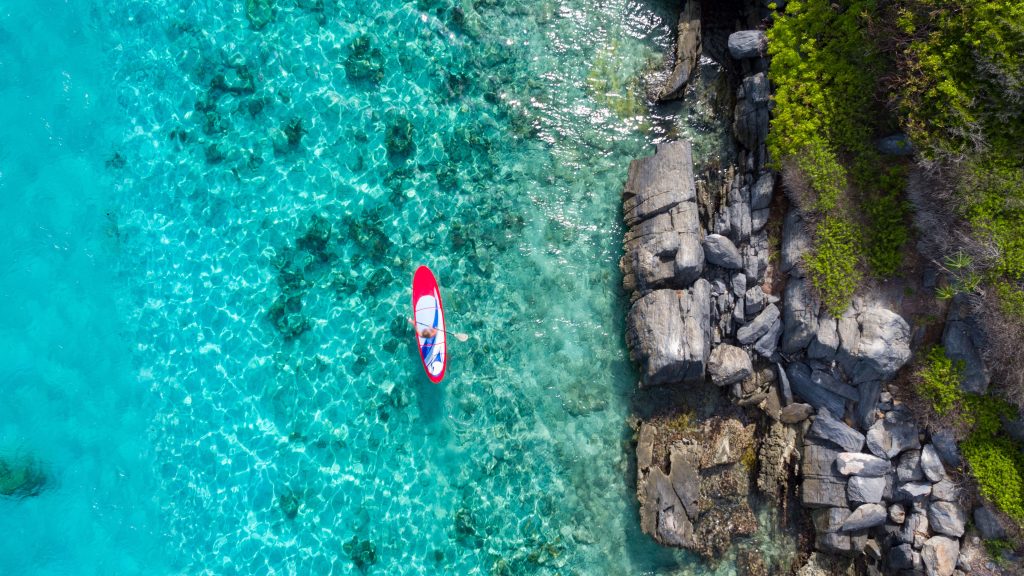 Woman on paddleboard in tropical water, Lovango Cay, US Virgin Islands, USA