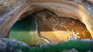 Read more about the article Warm sunset light on the sand, rock and water at Benagil Cave, Lagoa, Faro, Portugal